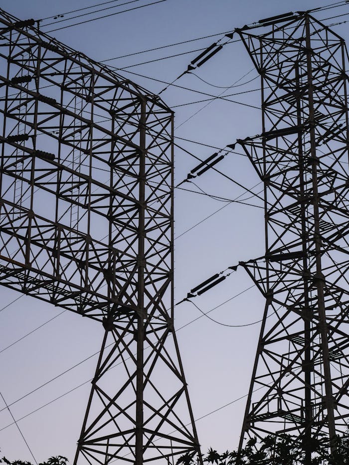 Silhouetted power towers against a twilight sky, showcasing industrial strength.